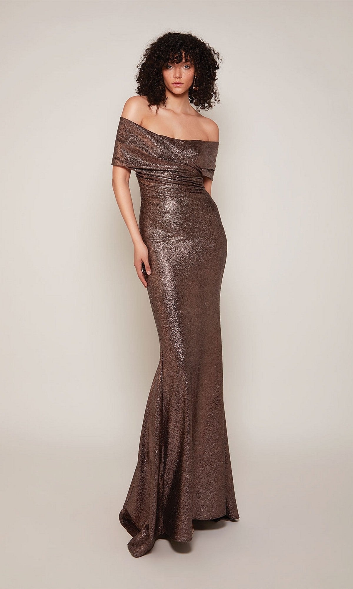 A woman models the Alyce 27666 long formal dress, a metallic off-the-shoulder mother-of-the-bride evening gown, standing against a plain light background.